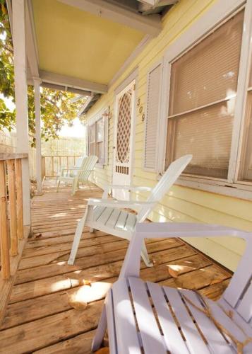 a porch with two chairs and a table and a window at Beaufort Harbour Suites East Lodge in Beaufort