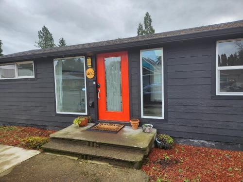 a black house with an orange door and a porch at It's Springtime in the PNW, come on out and enjoy! in Hillsboro