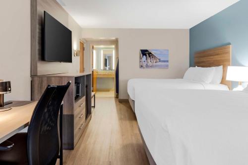 a hotel room with a bed and a desk and a tv at Best Western Plus Wilmington / Wrightsville Beach in Wilmington