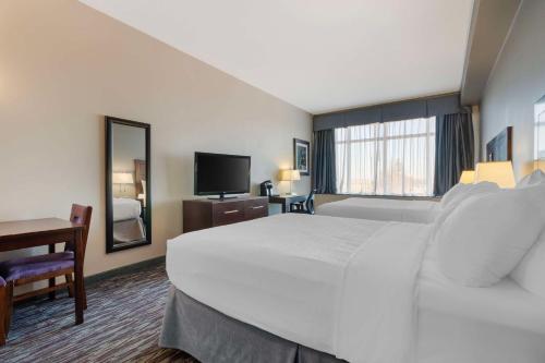 a hotel room with a large bed and a television at Best Western Plus Brandon Inn in Brandon
