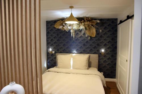 a bedroom with a bed and a chandelier at Le Jardin Secret - Balnéo & SPA in Montpellier