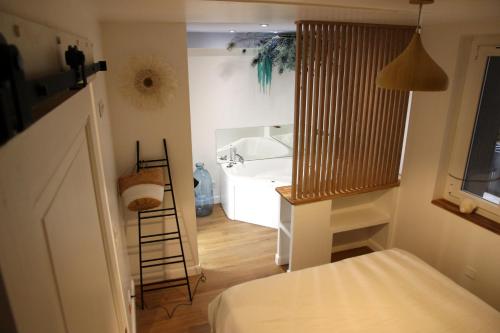 a bedroom with a sink and a bathroom with a ladder at Le Jardin Secret - Balnéo & SPA in Montpellier