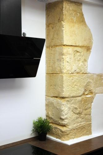 a stone wall with a television on a wall at Le Jardin Secret - Balnéo & SPA in Montpellier