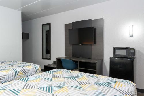 a hotel room with two beds and a tv at Motel 6-Cincinnati, OH in Cincinnati
