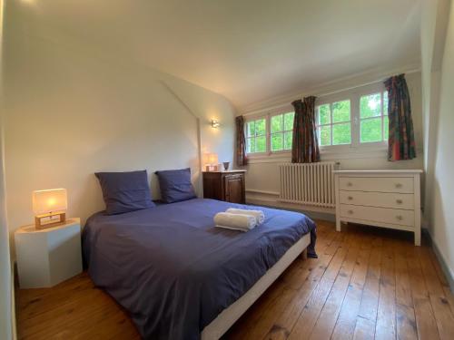 a bedroom with a bed with blue sheets and two windows at La Demeure du Domaine de Tertu, 12p, PISCINE in Villedieu-lès-Bailleul