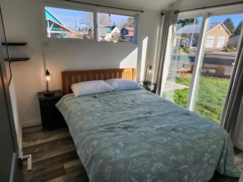 a bedroom with a bed and a large window at It's Springtime in the PNW, come on out and enjoy! in Hillsboro