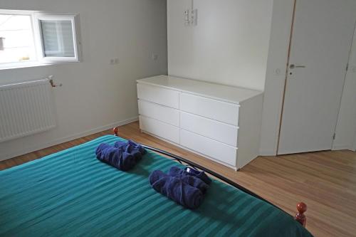 a bedroom with a bed with two blue pillows on it at Appartement entier 2 chambres Chez Zarius in Athis-Mons