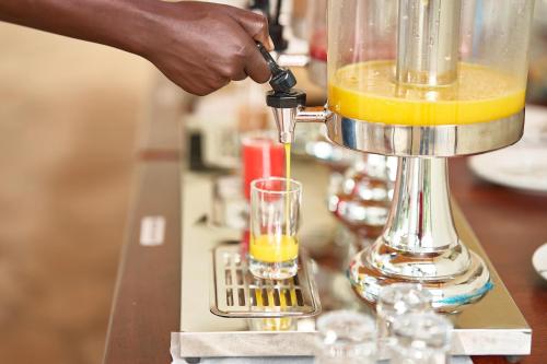 a person is making a drink in a blender at Igwara Lodge in Kamdini