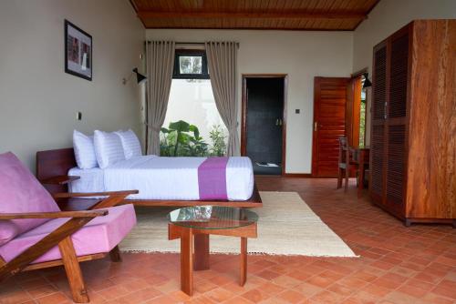 a bedroom with a bed and a couch and a table at Igwara Lodge in Kamdini