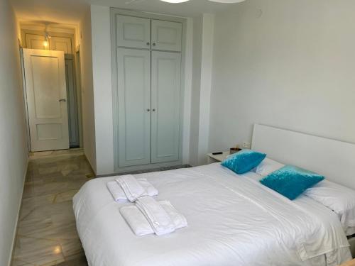 a bedroom with a large white bed with blue pillows at Delphinhaus in Almuñécar