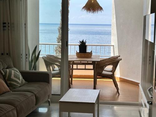 a living room with a table and a view of the ocean at Delphinhaus in Almuñécar