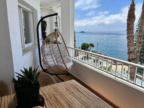 a hanging hammock on a balcony overlooking the ocean at Delphinhaus in Almuñécar
