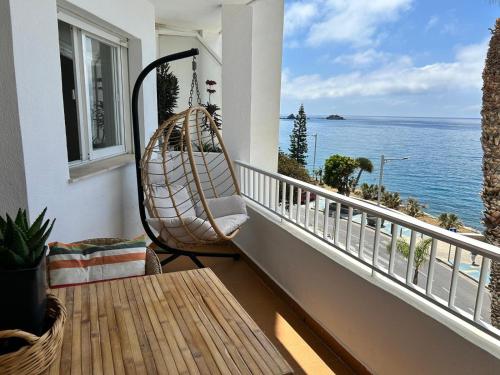 a porch with a hammock on a balcony overlooking the ocean at Delphinhaus in Almuñécar