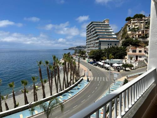 a view of a street with palm trees and the ocean at Delphinhaus in Almuñécar