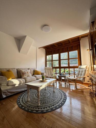 Una sala de estar con un sofá y una mesa de café. en Dúplex Aravedes en Potes, en Potes