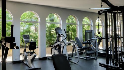 a gym with treadmills and ellipticals and windows at Barceló Santo Domingo in Santo Domingo