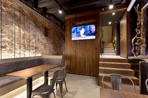 a restaurant with a table and chairs and a tv on the wall at Hostal Noria in Tarragona