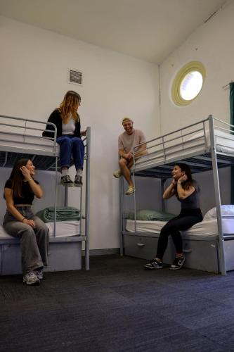 a group of people sitting on bunk beds at Nomads Sydney in Sydney