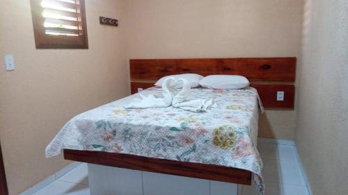 a bedroom with a bed with a wooden headboard at Complexo Turístico Gruta da Serra in Guaramiranga