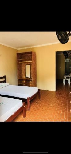 a room with two beds and a chair in it at Complexo Turístico Gruta da Serra in Guaramiranga