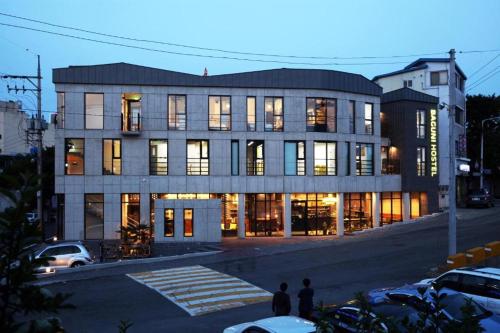 a large building with many windows on a city street at Baguni Hostel in Suncheon