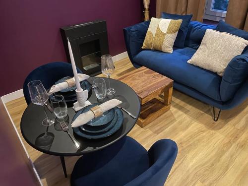 - une table avec des assiettes et des verres à vin dans le salon dans l'établissement Le Cocon des Granges - Suite Sauna Jaccuzi SPA, à Bonnières-sur-Seine