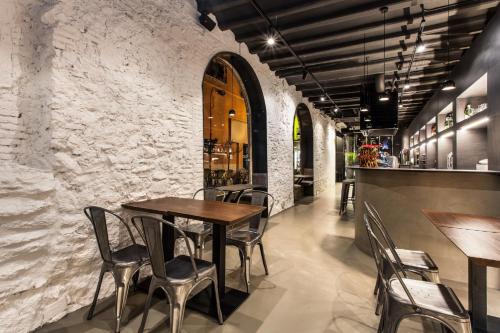 un restaurante con mesas y sillas de madera y una pared de piedra. en Hostal Noria, en Tarragona