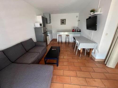 un salon avec un canapé et une table et une cuisine dans l'établissement Rez de villa bordure Ajaccio, à Ajaccio