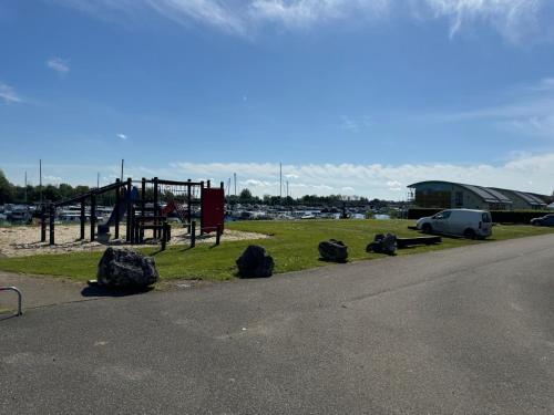 a park with a playground with a car and rocks at Hausboot KOMET Luxus und Natur pur max 5 Pers in Maasbommel