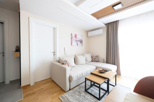 a living room with a white couch and a table at Apartman North resort in Vrnjačka Banja