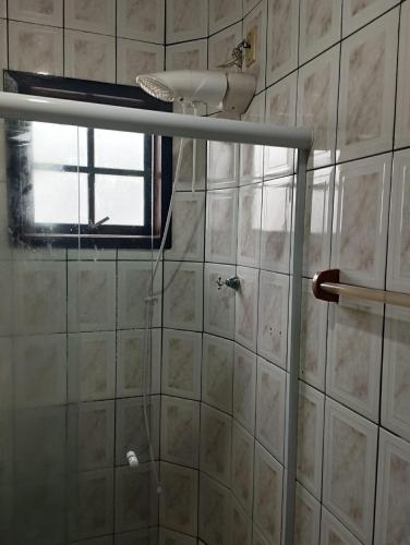 a shower in a bathroom with a window at APARTAMENTO SIMPLES E ACONCHEGANTE in Paraty
