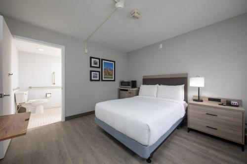 a bedroom with a large white bed and a bathroom at The Jackson SouthTown in Jackson