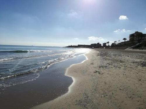a beach with waves coming in from the ocean at CHALET A 5 METROS DEL MAR.Wifi gratis in Murcia