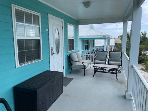 a blue house with a porch with chairs and a table at 12 South Harbor View in Georgetown