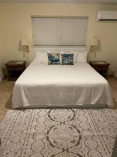 a bedroom with a large white bed with two night stands at 12 South Harbor View in Georgetown