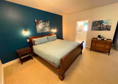 a bedroom with a bed and a blue wall at The Edenwild Boutique Inn in Lopez