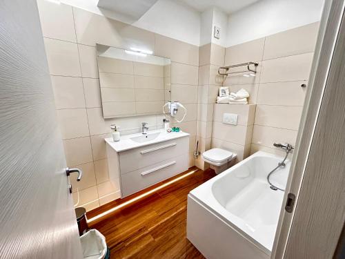 a bathroom with a sink and a tub and a toilet at Luna Studio White Tower in Mamaia