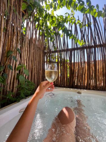 a person holding a glass of wine in a bathtub at Vila Ypáwa 150 m centro 30 m praia lago verde in Alter do Chao