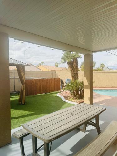 a wooden bench sitting under a pavilion on a patio at Paradise in Las Vegas