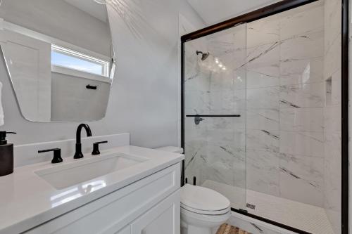 Un baño blanco con lavabo y ducha. en Tenor - Private Rooftop - 8 mins to Broadway, en Nashville