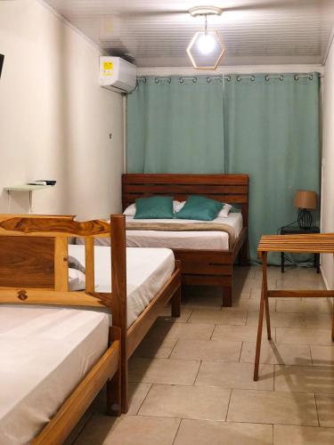 a room with two beds and two tables in it at Hostal Síndigo in Chitré