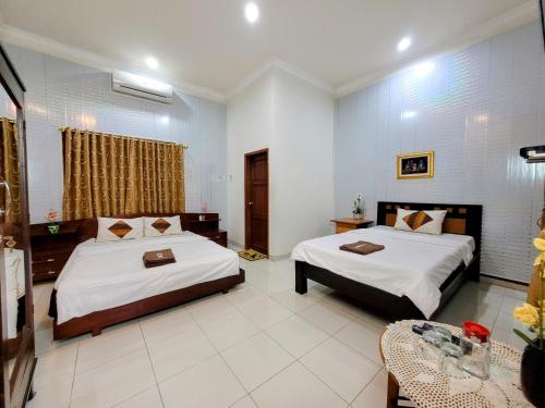 Postel nebo postele na pokoji v ubytování Ndalem Katong Guest House Ponorogo