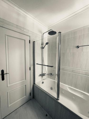 a bathroom with a shower and a bath tub at Nova Beach in Oeiras