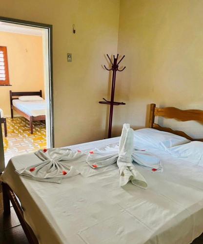 a bed in a room with a cross on the wall at Complexo Turístico Gruta da Serra in Guaramiranga