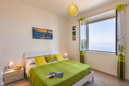 ein Schlafzimmer mit einem grünen Bett und einem großen Fenster in der Unterkunft Holiday home in Cala Gonone - Nuoro (Provinz) 22967 in Cala Gonone