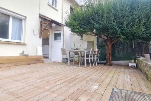 d'une terrasse avec une table, des chaises et un arbre. dans l'établissement Charmante Maison avec extérieur - Astérix & CDG, à La Chapelle-en-Serval