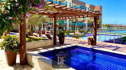 a swimming pool with a hammock and a swimming pool at Vg Fun by Diego Flats in Fortaleza
