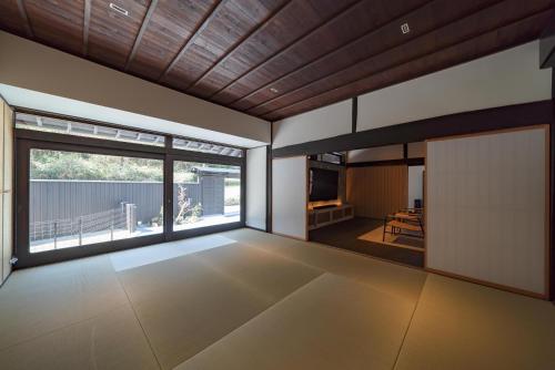 an empty living room with a large window at 小塩の灯り 石垣の別荘 in Ukiha