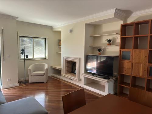 a living room with a television and a fireplace at Nova Beach in Oeiras