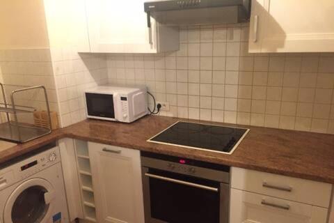 une cuisine avec un micro-ondes et une cuisinière four supérieur dans l'établissement Résidence proche gare RER, à Noisy-le-Grand